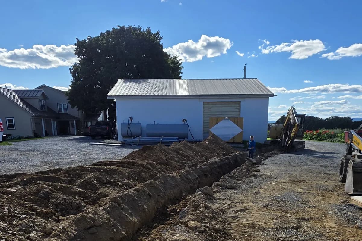 Open trench across a farm yard for underground feeders