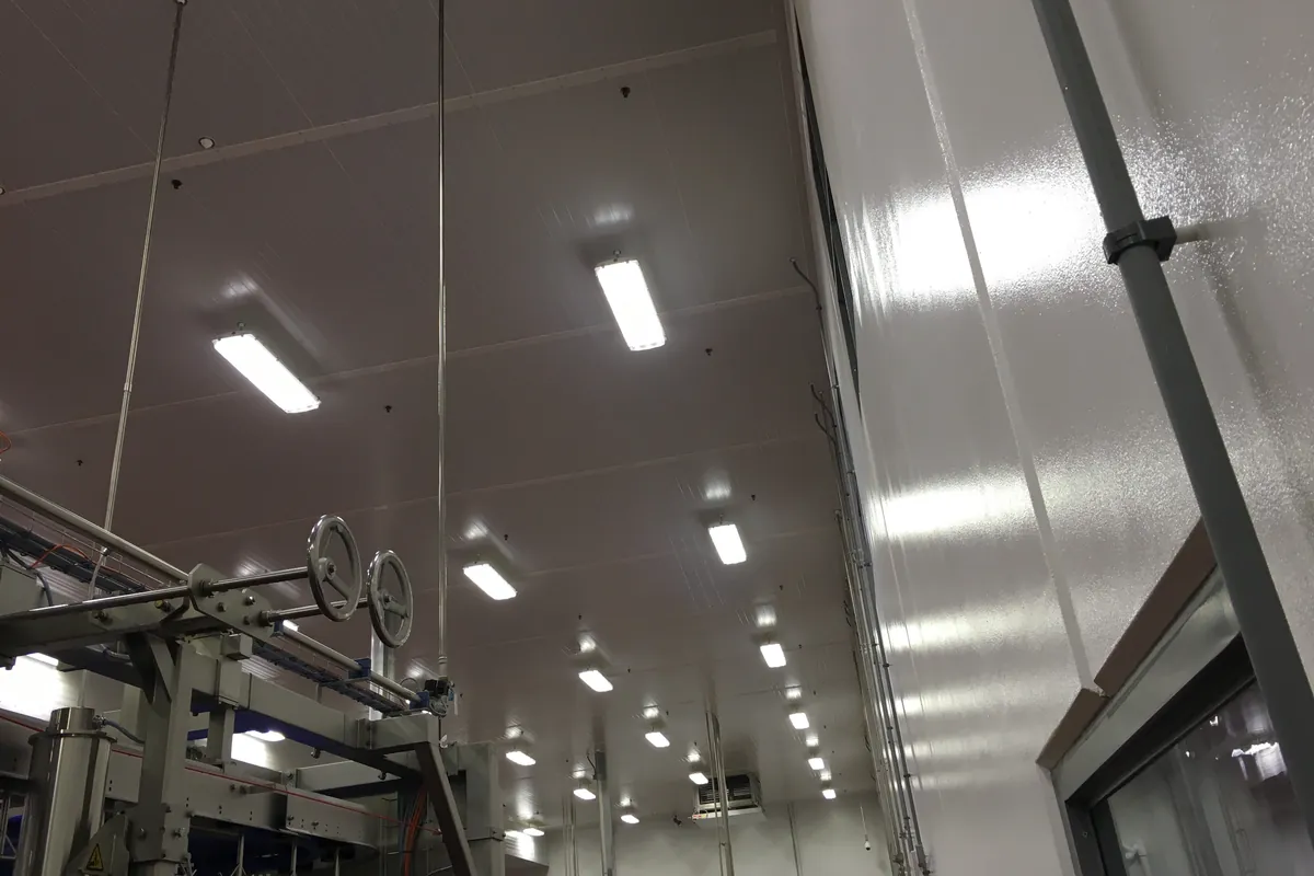 Long agricultural building with ventilation fans and interior lighting