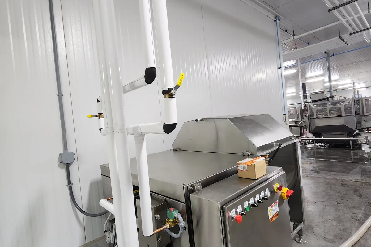 Food processing equipment with a control enclosure alongside