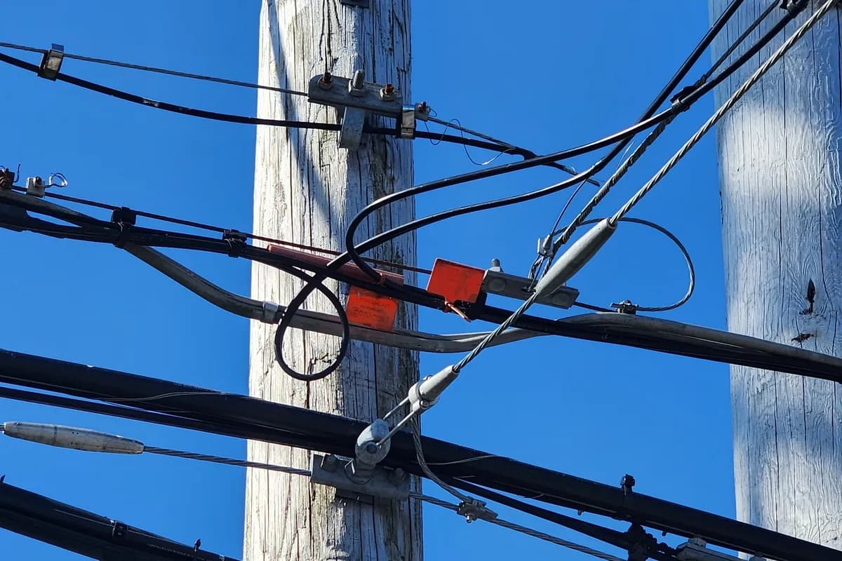 Utility pole with overhead conductors and a service drop splice