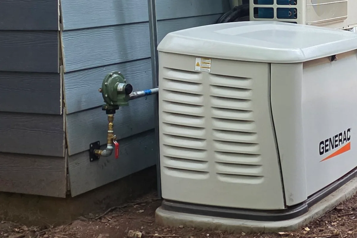 Standby generator and gas regulator installed beside a building