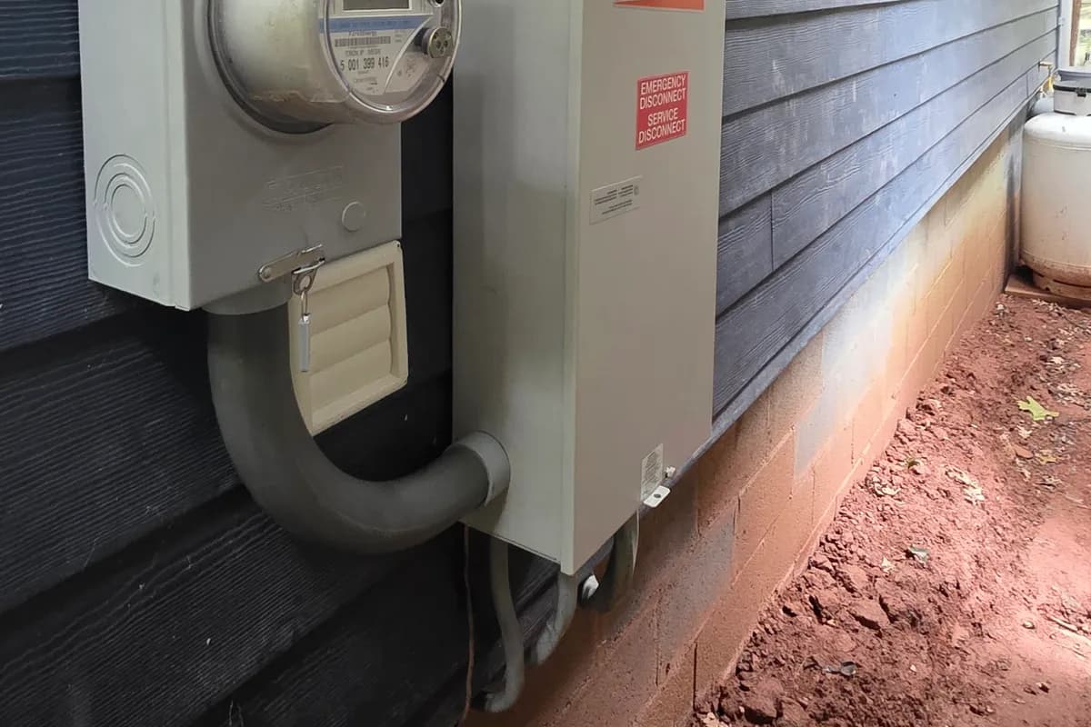 Meter socket and automatic transfer switch mounted on an exterior wall